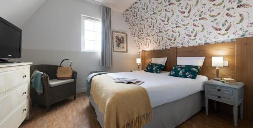 乌尔加特皮埃尔假日酒店的一间卧室配有一张床、一台电视和一把椅子