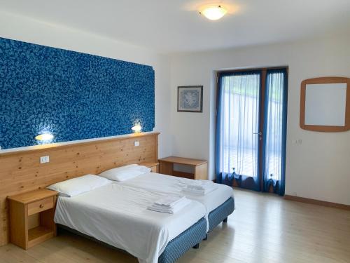 特伦托阿格里图维奈托旅馆的一间卧室设有一张蓝色墙壁的大床
