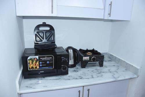 伊斯兰堡HYATT ARYANA Guesthouse 1的厨房柜台配有微波炉和收音机。