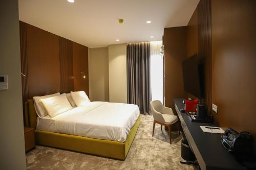 地拉那Urbanin Apartment & Hotel的配有一张床和一张书桌的酒店客房