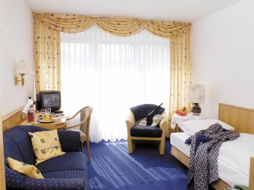 巴特基辛根维托埃里卡酒店的酒店客房,配有一张床、一张桌子和椅子