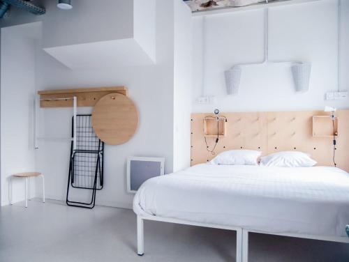 诺伊斯·勒·格兰德Ecla Paris Noisy-le-Grand的卧室配有白色的床和木制床头板