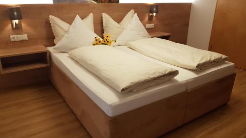 芬德尔斯Pension Burgschroffen的一张配有白色床单和枕头的大床