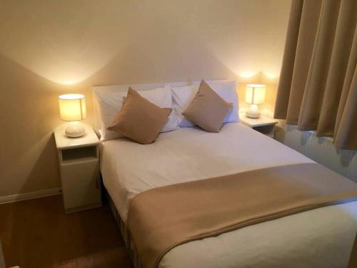 帕兹托Marios Lodge的一间卧室配有一张带两盏灯的大型白色床。