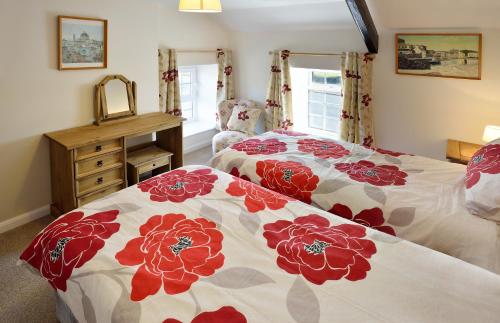 卡斯尔敦可诺达格度假屋的一间卧室配有两张带红白毯子的床
