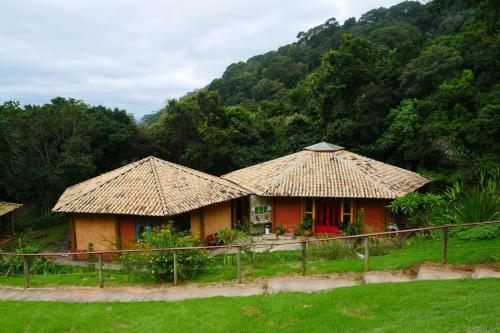 伊克斯雷玛Pousada Spa Saúde Melhor的两栋房子,茅草屋顶在田间