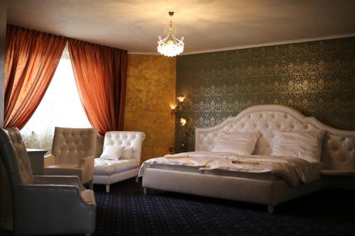 布拉迪斯拉发克托娃汽车旅馆的一间卧室配有一张床、一把椅子和一个吊灯。