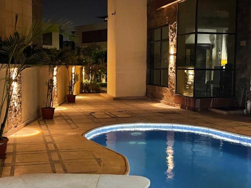 开罗Awesome Villa on a hill Families only的夜间在房子前面的游泳池