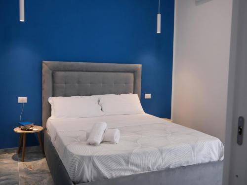 那不勒斯Attico Central Station Napoli的一张带两个枕头的床和蓝色的墙壁