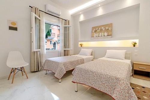 AnemómylosWhite nest in Corfu town的一间卧室设有两张床和窗户。