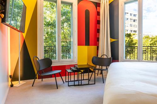 巴黎Graphik Montparnasse的一间卧室配有一张床、椅子和窗户。