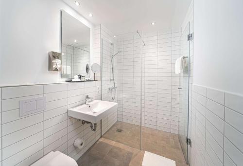 奥格斯堡elaya hotel augsburg的白色的浴室设有水槽和淋浴。