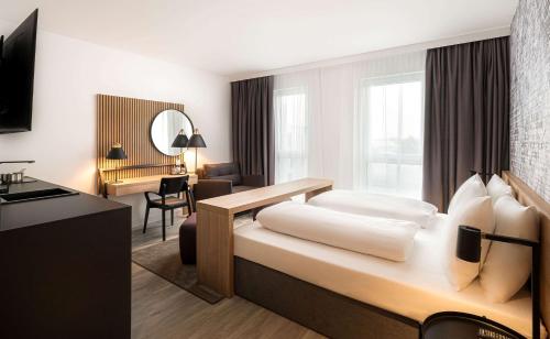 奥格斯堡elaya hotel augsburg的配有一张床和一张书桌的酒店客房