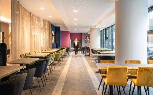 奥伯豪森elaya hotel oberhausen ehemals ANA Living Oberhausen by Arthotel ANA的餐厅里一排桌椅