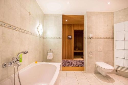 上乌瑟尔elaya hotel frankfurt oberursel的带浴缸和卫生间的浴室。