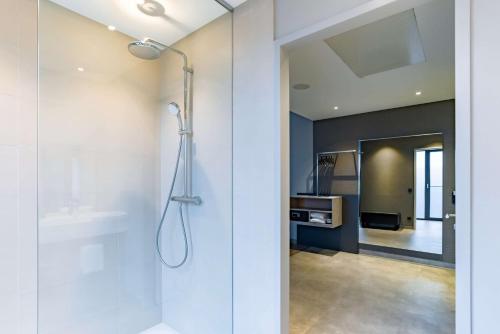 凯沃拉尔elaya hotel kevelaer的带淋浴的浴室和玻璃门