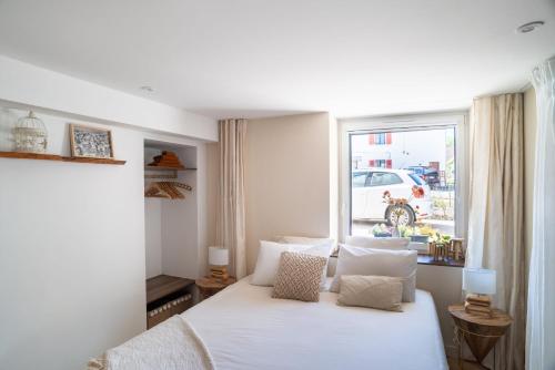 埃沙内韦Charmant Studio paisible dans le Centre du Village的卧室配有白色的床和窗户。