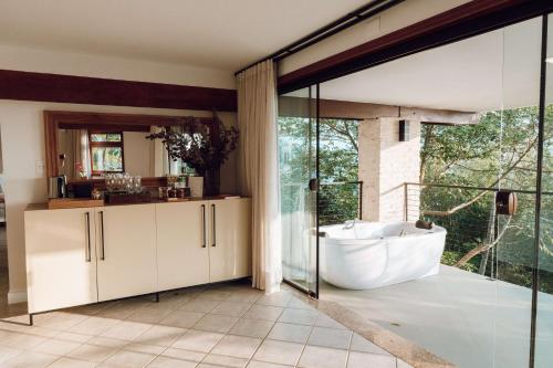 弗洛里亚诺波利斯Naatooh Guest Houses的带浴缸的浴室和大窗户