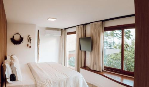 弗洛里亚诺波利斯Naatooh Guest Houses的一间卧室设有一张床和一个大窗户