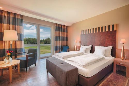 艾托弗西格股份有限公司古特汉肯霍夫高尔夫度假酒店的酒店客房设有一张大床和一张书桌。
