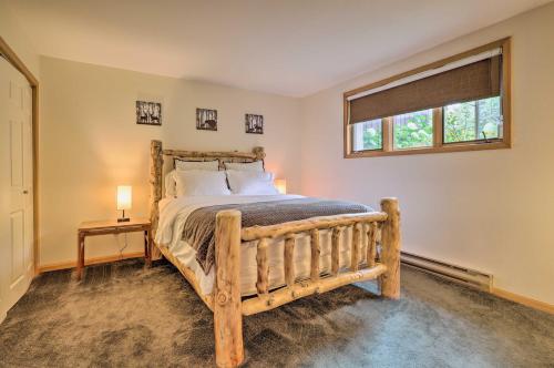 普莱西德湖Lake Placid Condo with Patio - Walk to Beach!的一间卧室设有一张木床和一个窗户。