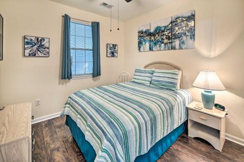 默特尔比奇Ground-Floor Condo with Community Perks的一间卧室配有一张床和一个带灯的床头柜