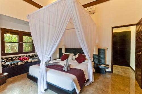 塞米亚克布鲁巴布别墅旅馆的一间卧室配有一张带天蓬的床