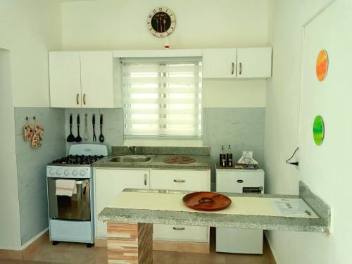 蓬塔卡纳Dominican Dream Apartments的厨房配有白色橱柜和柜台上的盘子