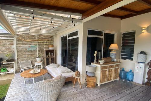 普纳奥亚Villa WABISABI cosy home的平台上设有带沙发和桌子的庭院