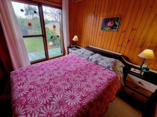 伊瓜苏港La Morada del Sol的卧室配有粉红色的床和窗户。