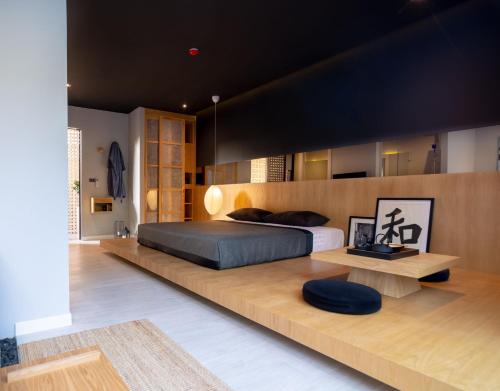他朗Villoft Zen Living Resort的一间卧室设有一张大床和一张木凳