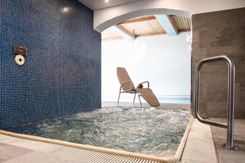克洛斯特斯斯尔瑞特塔公园酒店的一个带按摩浴缸的浴室,配有椅子