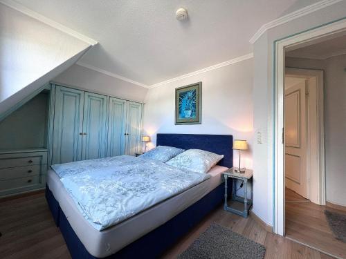 韦斯特兰Meer-Lust-Sylt sea cottage的一间卧室配有一张蓝色床头板的床