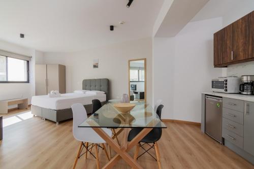 雅典Leochares Lifestyle Apartments - Self check-in的厨房以及带桌子和床的用餐室。