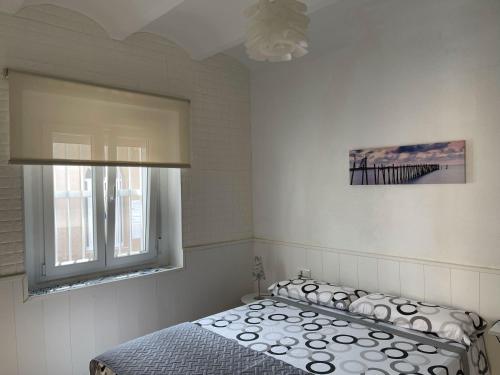 圣卡洛斯拉腊皮塔Lleida 25, casa de poble a planta baixa amb àmplia terrassa equipada的一间卧室设有一张床和一个窗口