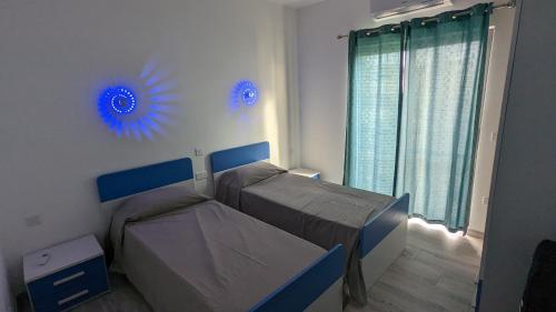艾因西莱姆Paradise的卧室配有两张床,墙上装饰有蓝色调