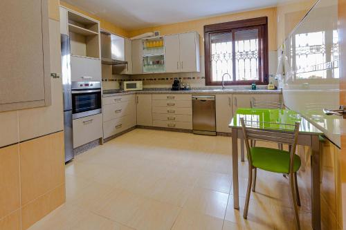 鲁特Villa Viana的厨房配有桌子和绿色椅子