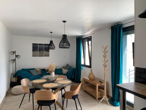 RanvilleLa maison de la vallée的客厅配有蓝色的沙发、桌子和椅子
