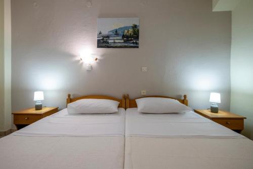 帕拉利亚卡泰里尼斯Lucia Hotel Paralia的卧室内的两张床,墙上有两盏灯
