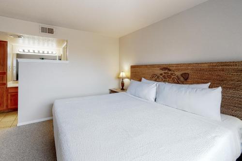 帕德雷岛Mystic Harbor 207的卧室配有白色的床和木制床头板