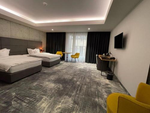 阿拉德Aniroc Signature Hotel的酒店客房设有两张床和一张桌子。