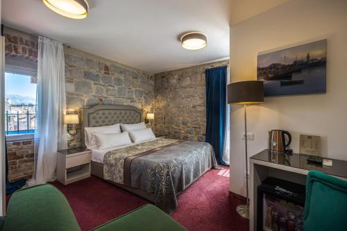 斯普利特Hotel Agava Split的一间卧室设有一张床和石墙