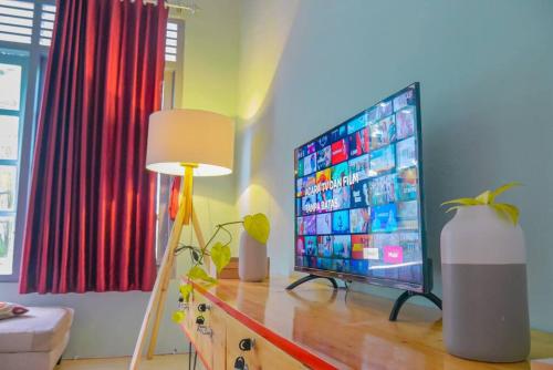 斯勒曼Homestay Kamar Tamu Selomartani 3的客厅配有梳妆台上的电视