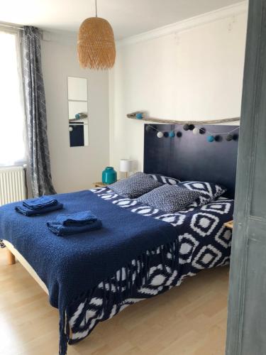 埃特勒塔La courtine Etretat maison de pêcheur 2 mn de la mer的一间卧室配有一张带蓝色棉被的床