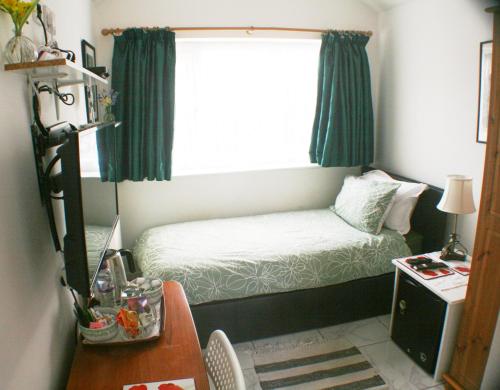 ThurstastonWoodside Lodge的一间小卧室,配有床和窗户