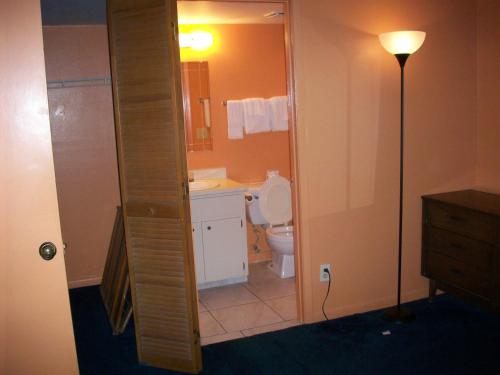 埃奇沃特LLC全套房汽车旅馆的浴室配有卫生间、水槽和台灯。
