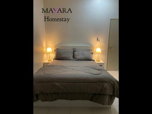 汝来MAYARA Homestay @ Residensi Lili的一间卧室配有一张带两盏灯的床。