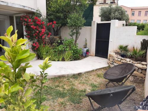 皮埃尔弗-迪瓦尔Appartement climatisé au calme en Provence的院子内带两把椅子和鲜花的花园