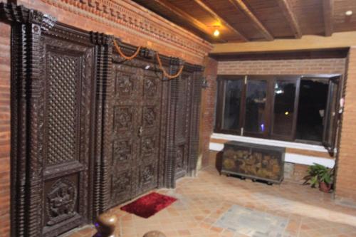 加德满都世界遗产公寓酒店 的客房设有壁炉和大型木墙。