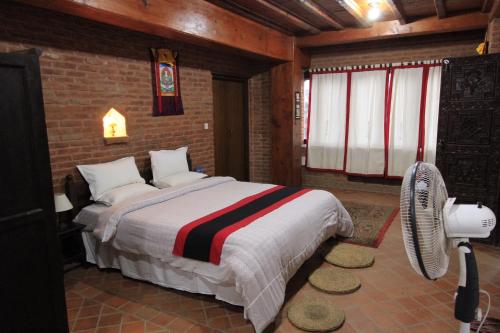 加德满都世界遗产公寓酒店 的一间卧室配有一张大床和风扇